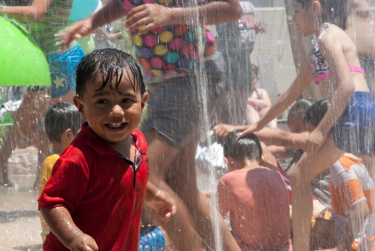 Kids playing under a water feature