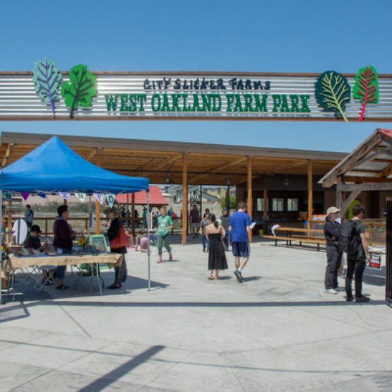 People strolling at market stalls in the West Oakland Farm Park