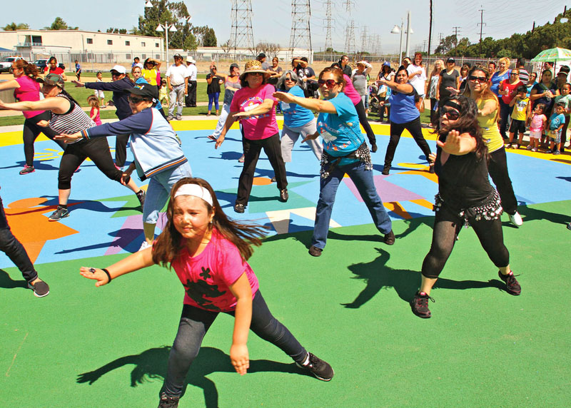 A group of girls and women exercising on a colorful new outdoor exercise area