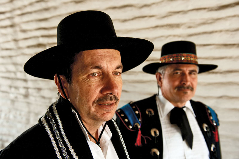 Two men in historic reenactmnent clothing and hats