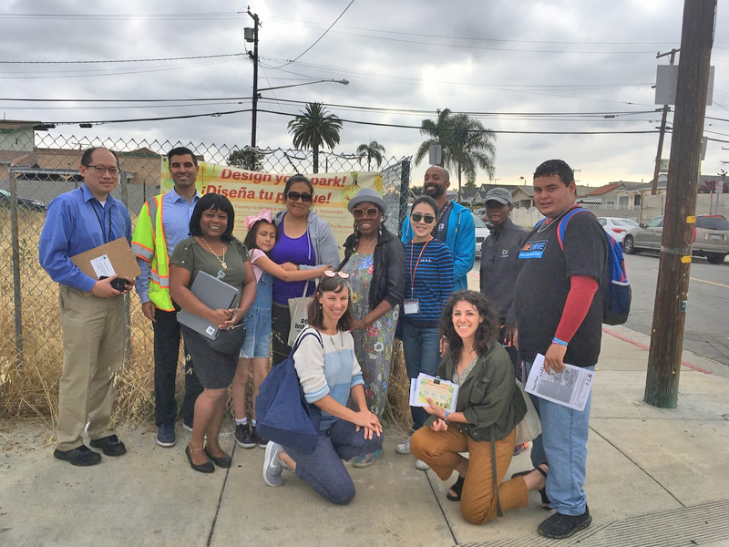 Group of people posing in front of vacant lot during community engagement event