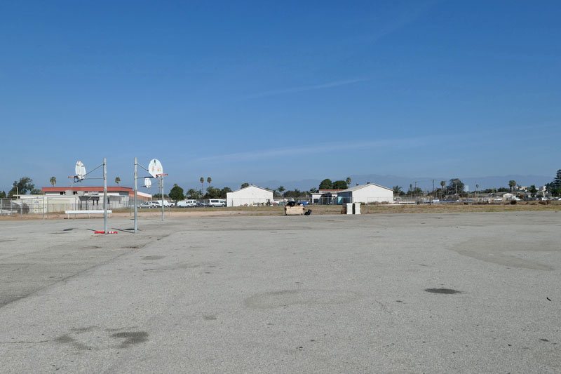 Paved area with two basketball hops.