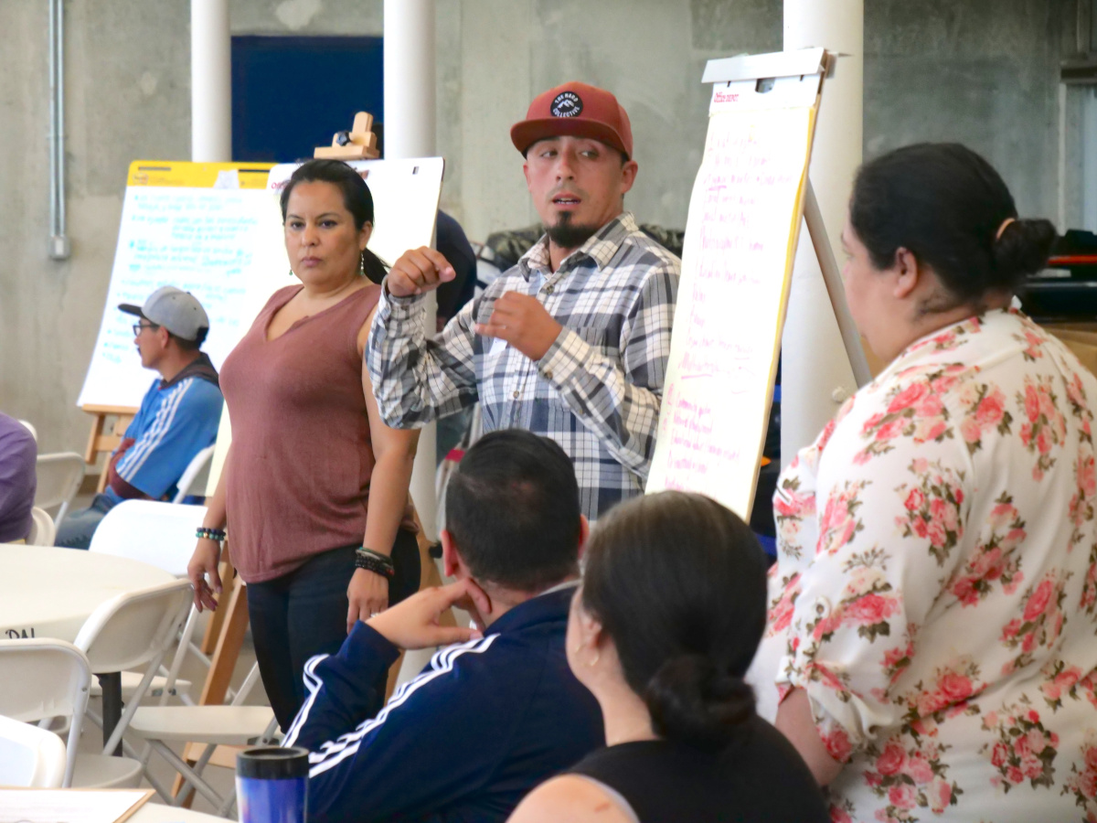 Man presents his group's ideas to the larger group of people gathered'