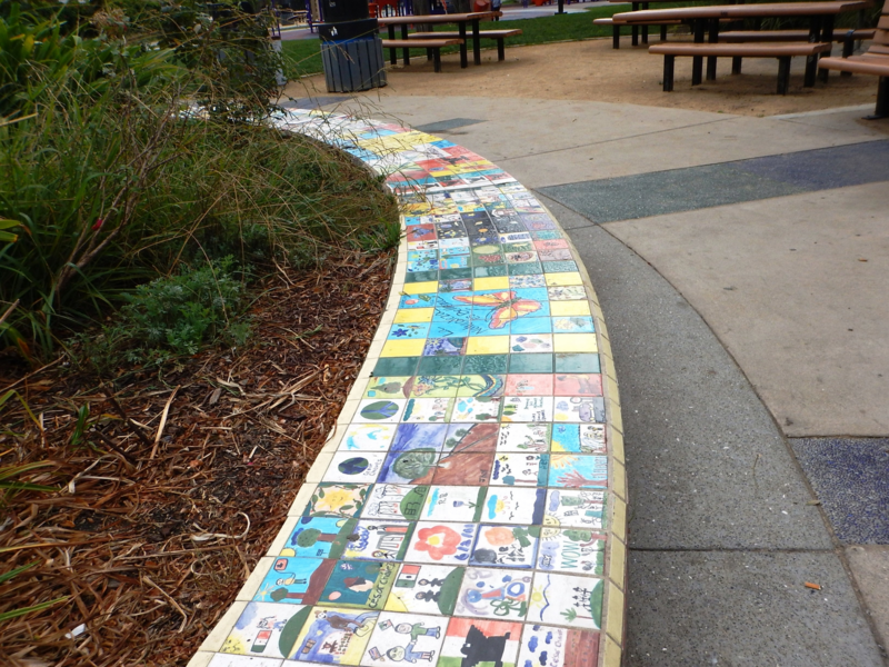 Circular bench covered with hand-drawn art tiles.