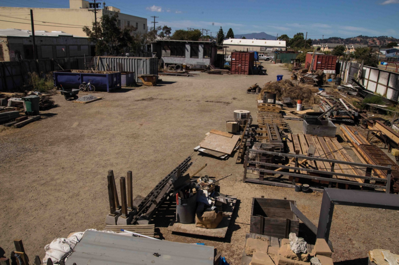 Vacant lot with containers and construction materials.