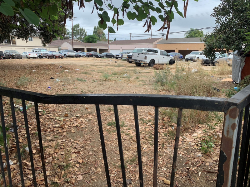 Vacant lot with many cars parked.