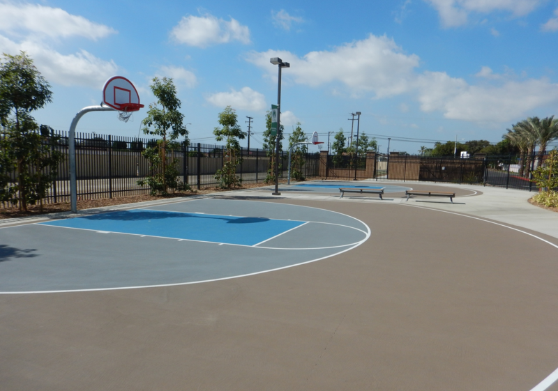 Two side-by-side outside basketball courts with single hoop.