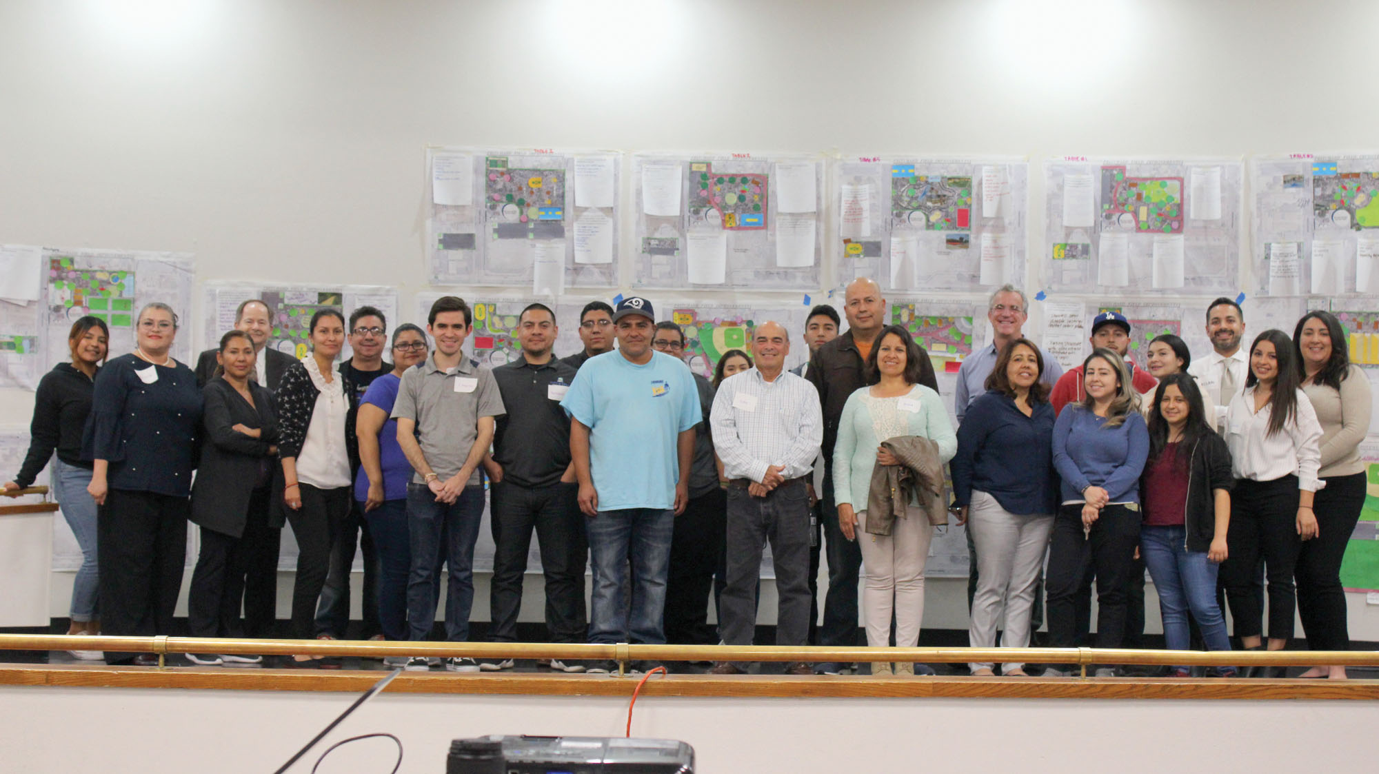 A group of people after a park planning process with planning documents on the wall behind them