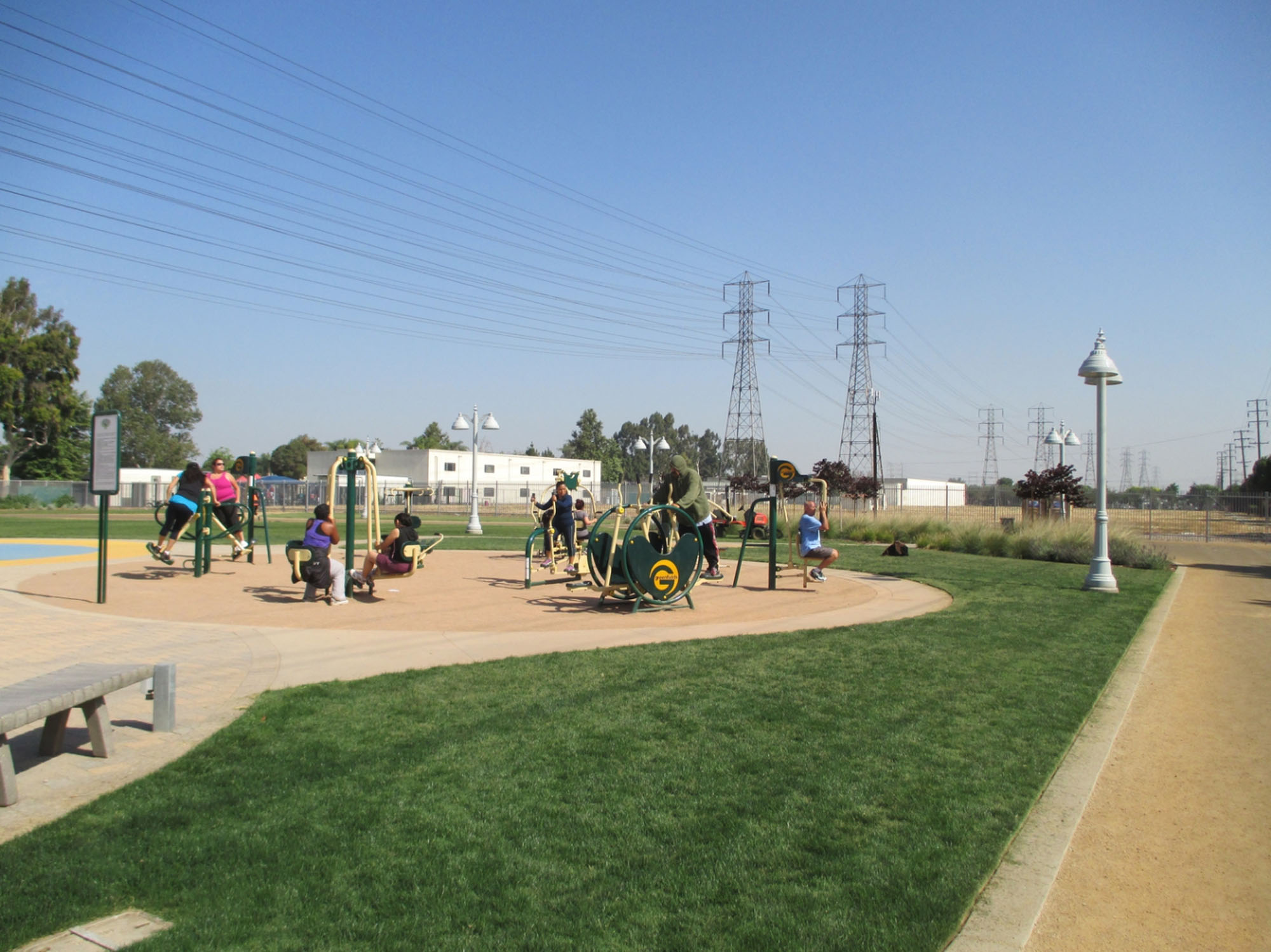 People using new outdoor exercie equipment on a sunny day