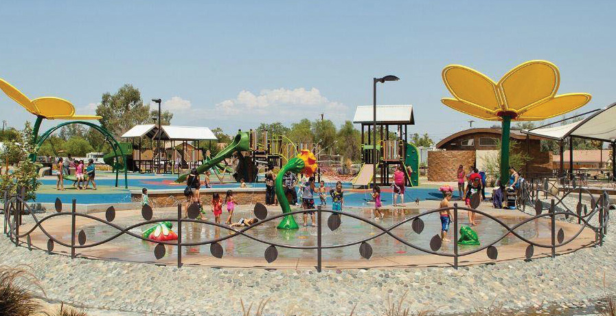 Children playing in a splash park with flower-shaped fountains